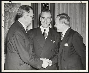 Hands Across a Sometimes Stormy Sea - It was official, but it was heartfelt - this greeting between British Consul General Bernard Sullivan (left) and Irish Consul Joseph D. Brennan (right) at Hotel Statler today. Mayor Kerrigan watches gesture of friendship made at luncheon he tendered to two officials stationed in Boston.