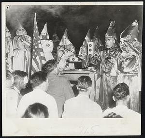 Grand Dragon Initiates New Klansmen-Dr. Samuel Green (holding sword), Grand Dragon of the Ku Klux Klan initiates kneeling candidates for the order (foreground) in ceremony on Stone Mountain near Atlanta, Ga.