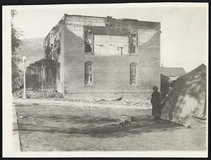 Tent Is "Home" In Quake Zone. Helena, Montana, Oct. 19 -- Fearing additional earthquake shocks, one family here is living in that tent at the right. In the background is the damaged apartment house of S.R. Murfitts and G.R. Peterson, on Breckinridge St., where two persons were injured fleeing from the quake as the porch collapsed about them.