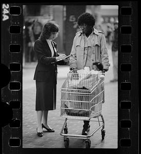 Market researcher interviews customers at shopping mall in Brighton