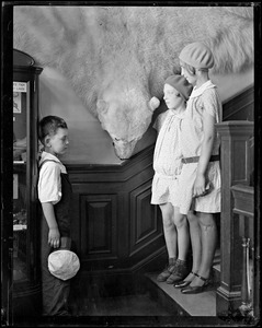 Three children stand by a taxidermy polar bear