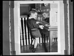 Boy looking inside dollhouse