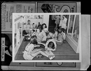 Children seated near doll exhibit