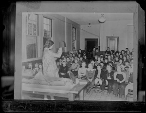 Woman gives a lecture to seated children