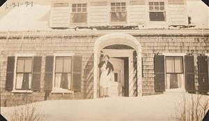 Home of George and Harriet Thoms Chase with Harriet Chase standing on snow by front door, West Yarmouth, Mass.