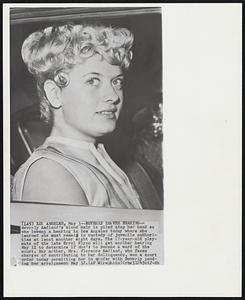 Beverly Leaves Hearing-- Beverly Aadland's blond hair is piled atop her head as she leaves a hearing in Los Angeles today where she learned she must remain in custody of juvenile authorities at least another eight days. The 17-year-old playmate of the late Errol Flynn will get another hearing May 11 to determine if she's to become a ward of the court. Her mother, Mrs. Florence Aadland, who faces charges of contributing to her delinquency, won a court order today permitting her to confer with Beverly pending her arraignment May 12.