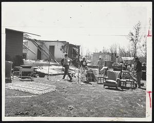 A Scene Familiar to Householders in the Worcester area the morning after tornado struck, was this picture taken at the home of Mrs. Kenneth G. Kirby of South Main st., Holden. Neighbors assist in salvaging personal possessions.