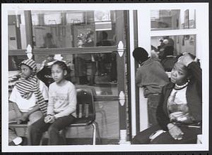 Young girls and a woman sitting in chairs