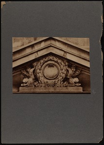 Ornate pediment with wreath cartouche and dolphin on each side, above entrance to First National Bank building, New Bedford, MA