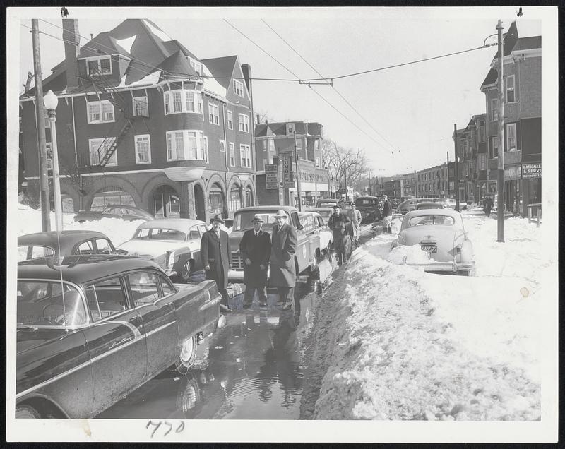 Why Trolley Buses Are Not Running along Washington street in Dorchester is demonstrated in this photograph. IT is the trackless trolley line between Ashmont and Dudley street by way of Warren street. MTA officials Charles W. McCarron, Edward Dana and Herbert Baldwin take a look.