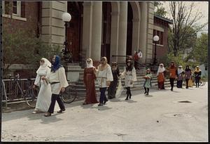 Group in costumes walking past Lawrence Library