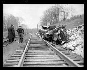 Wrecked Gulf truck overturned by the side of railroad tracks