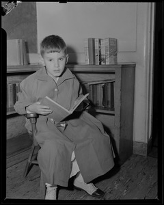 Boy reading book, possibly Children's Hospital