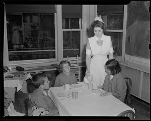 Children at table served by nurse, possibly Children's Hospital
