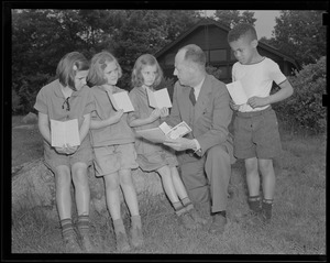 Edward J. Delaney showing U. S. defense savings stamps to Annie Canavon, Joan Lawson, Peggy DeStefani, and Thornton Barrows, children from the Prendergast Preventorium