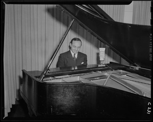 Unidentified man, possibly Frank Bolitzeo, playing piano at WEEI