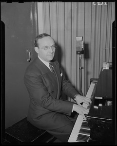 Unidentified man, possibly Frank Bolitzeo, playing piano at WEEI
