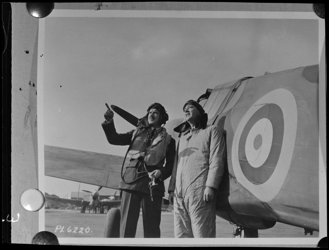 Two unidentified men, one of them possibly Steve Day, with plane