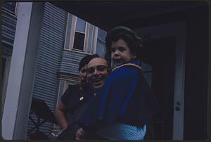Man, woman, and child standing on porch