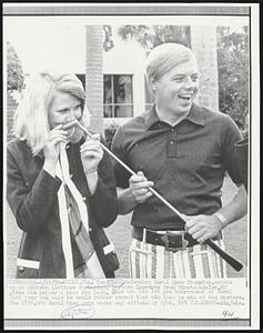 Miami, Fla. Tom Shaw, defending Doral Open Champion, cracks up as Eastern Airlines stewardess Barbara Lawrence from Winston-Salem, NC gives his putter a kiss for luck. Shaw won his 1st pro tournament at Doral last year and said he would rather repeat that win that to win at the Masters. The $150,000 Doral Open gets under way officially 2/26.