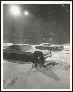 Weather Snowstorm 3/29/70. Worker digs out his car on Harrison Ave.