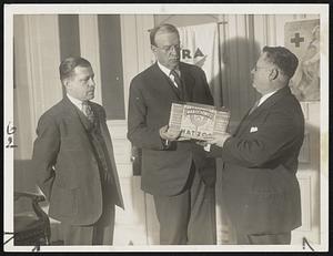 With the Jewish Passover drawing near, a million-pound shipment of "matzos" arrived in Boston today and photo shows the first package being presented to Mayor Mansfield by Samuel Fisher (right), while Harry H. Goldstein, manager of the M. and P. Theatre, Roxbury, looks on.