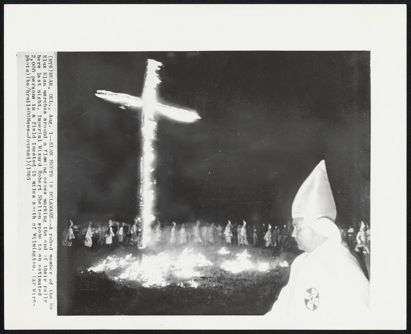 Klan Meets in Delaware--A robed member of the Ku Klux Klan marches around a flaming cross marking the end of their rally here last night. Imperial Wizard Robert Shelton spoke to an estimated 2,000 persons in a field located 15 miles south of Wilmington.