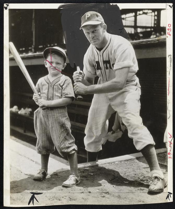 Nothing Like an Early Start- It's Rip Sewell, leading pitcher for Pittsburgh Pirates, giving lesson in batting to his 4-year-old son Jimmy. The pitching lessons will come later.