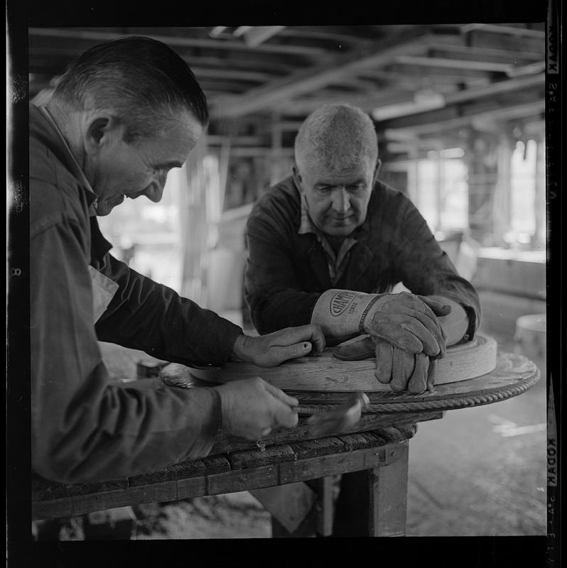 Pert Lowell, right, and others working in boat shop