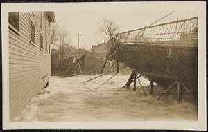 Main St. bridge being swept away by flood waters