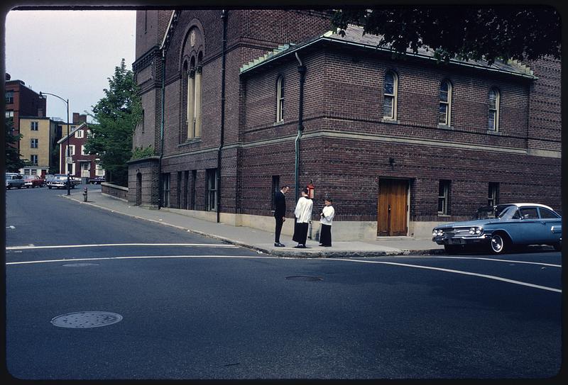 Man talking to altar boys outside St. Paul's church, Cambridge, Massachusetts