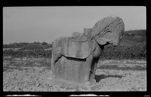 Stone animal carving in field