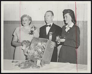 Dutch Tulip Bulbs sent by Dutch Baptists in Amsterdam Holland, were presented to guests last night at the annual formal ladies' night dinner of the Boston Baptist Social Union at Mechanics Building. Left to right are Mrs. Norman H. Abbott, president of the women's union; Carleton W. Crook, president of the men's union, and Jackie O'Connor of Lexington, American Airlines stewardess on plane that flew bulbs here.