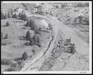 Main Highway Washed Out- This aerial view shows washed-out sections of U.S. Route 20 at Charlton, Mass, yesterday, which was washed out by heavy rains that drenched southern New England with up to 12 inches of rain .