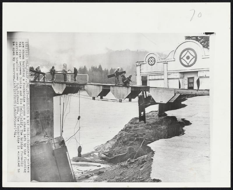 Building a Way Back--Volunteer workers are shown building a footbridge across a chasm left by the flooding Eel river between Scotia and Rio Dell, Calif. The bridge formally carried traffic over U.S. Highway 101. The footbridge is expected to be open by tomorrow.