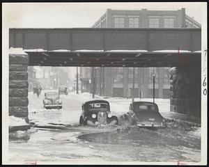 Amphibious Operation in Roxbury--Automobiles slosh through two feet of flood water under the Ruggles street bridge in Roxbury as ice and water make traffic tricky.