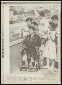 First Outing for Japan's Heart Recipient -- Nobuo Miyazaki, 18, in wheel chair, gets a view of the area surrounding the Sapporo Medical College Hospital in Hokkaido, Japan, last week, about a month after he became Japan's only heart transplant recipient. Nobuo spent about 10 minutes on the roof of the hospital. His mother, Tomi, smiles in left background.