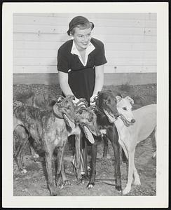 Mrs. Phyllis Gould of Arlington with four of the leading dogs from the R. K. Hutchings kennel, Sweetena, Capehart, Wicked, and New Dress, which will see action at Wonderland Park, Revere, this season. Wonderland Park open Wednesday, May 13.