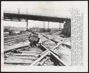 Lone Steel Picket Blocks Rails - Joe Mullen, Pittsburgh steel worker, reads reports on the nationwide steel strike today as he sits on a rail junction at entrance of huge Jones and Laughlin Steel corporation to "see to it that nothing is moved in or out this way." The idle plant is in background.