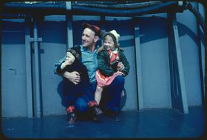 Man with two children on boat