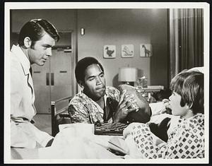 Football Great O.J. Simpson (center) who starred in the premiere of "Medical Center" last night, helps a young patient adjust to the loss of a hand over a game of checkers. Chad Everett (left) stars as the doctor in the CBS-TV series and Radames Pera played the boy whose hand was amputated.