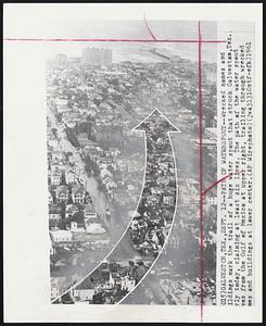 Path of Waterspout--Wrecked homes and buildings mark the trail of a huge water spout that struck Galveston, Tex., early today, claiming at least six lives. The path of the water spout from the Gulf of Mexico at upper right, trailing through wrecked homes and buildings at lower center.