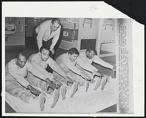 Milwaukee – Early Oof! For Braves – Four prominent members of the Milwaukee Braves reach for their toes under the watchful eyes of Ben Geraghty as they started limbering up exercises at County Stadium today. From left, they’re Billy Bruton, Frank Torre, Johnny Logan and Wes Covington.