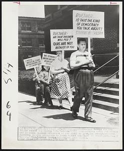 Detroit – Picket UAW-CIO headquarters – John Shures and his family picket the United Auto Workers (CIO) headquarters after the former UAW official claimed violation of his right to work. The family, carrying placards calling attention to their plight are (left to right) John Jr., 5; Norman, 7; Mrs. Lucille Shures, mother; and John Shures.