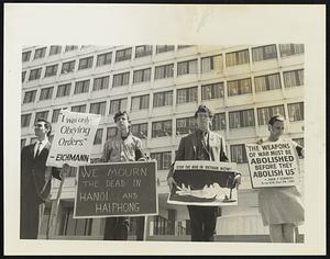 Four men holding anti Vietnam War signs