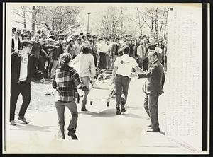 Hit By Gunfire in Campus Riot. A stretcher is rushed in to carry away a student hit by gunfire today in the fourth day of rioting by students of Kent State University in Northeast Ohio. Four persons were killed and at least 11 wounded as National Guardsmen attempted to halt the rioting students.