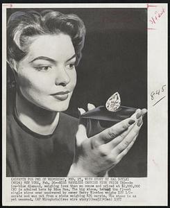 Miss Nameless Carries High Price Tag--An ice-blue diamond, weighing less than an ounce and priced at $2,000,000 (M) is admired here by Edna Rae. The big stone, termed the finest single stone ever uncovered by owner Harry Winston weighs 128 1/2-carats and was cut from a stone weighing 426 carats. The stone is as yet unnamed.