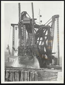 A dredge deepening the harbor floor off Governor's Island, one of the many now engaged in the harbor improvement program.