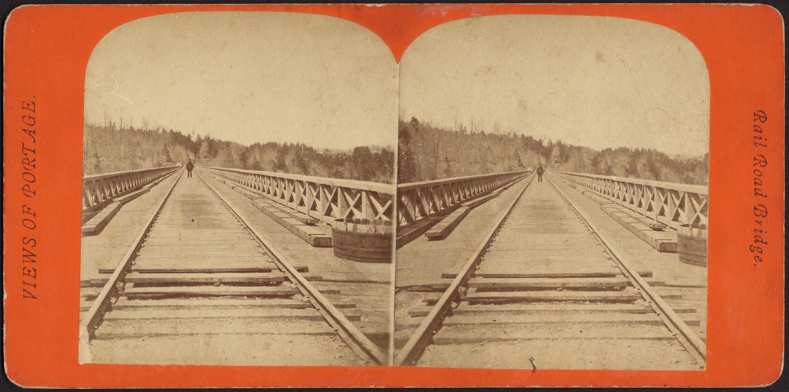 Railroad bridge, with a man standing on the tracks in the distance