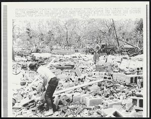 Long Beach, Miss: A woman moves blocks in a search for bodies at the remains of the Gulf Vista Apartments 8/18, where two bodies had already been found. In the background National Guardsmen aid in the search and protect against the possibility of looting in the wake of Hurricane Camille.